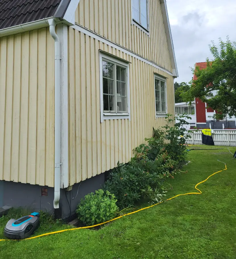 Samma träfasad efter fasadtvätt – ren och återställd i originalfärg